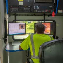 A BWSC employee looking at CCTV footage of inside a sewer/drain pipe